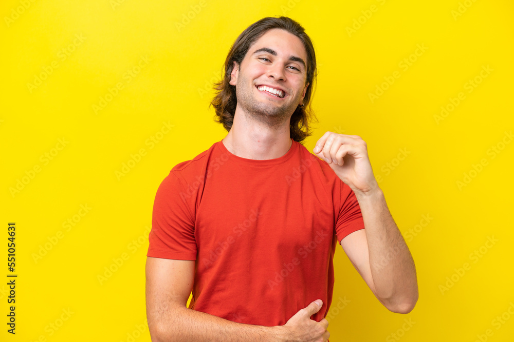Caucasian handsome man isolated on yellow background laughing Caucasian handsome man isolated on yellow background laughing