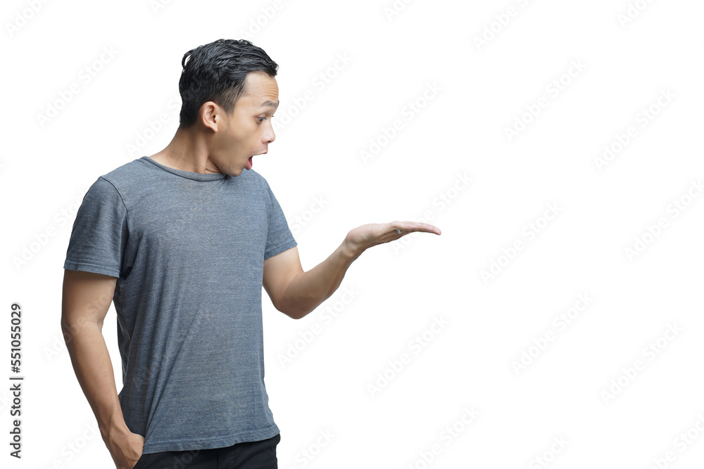 Asian man with shocked expression on isolated background holding copy space imaginary on the palm