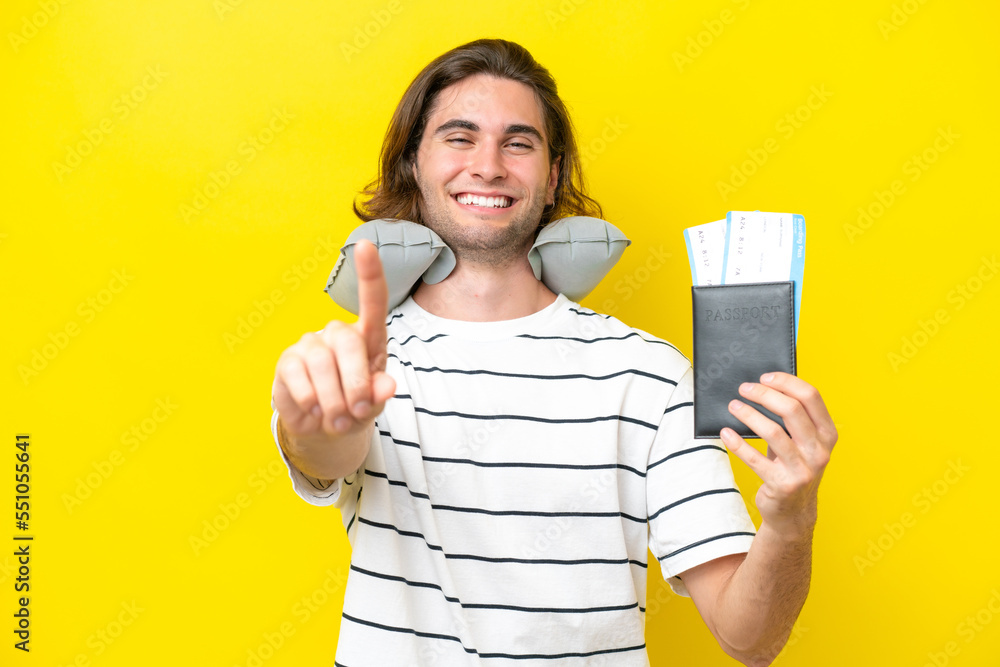 handsome Man with Inflatable Travel Pillow showing and lifting a finger handsome Man with Inflatable Travel Pillow showing and lifting a finger