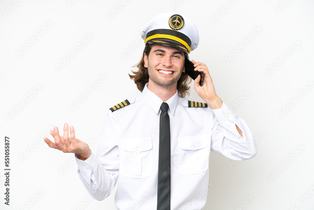 handsome Airplane pilot isolated on white background keeping a conversation with the mobile phone with someone handsome Airplane pilot isolated on white background keeping a conversation with the mobile phone with someone