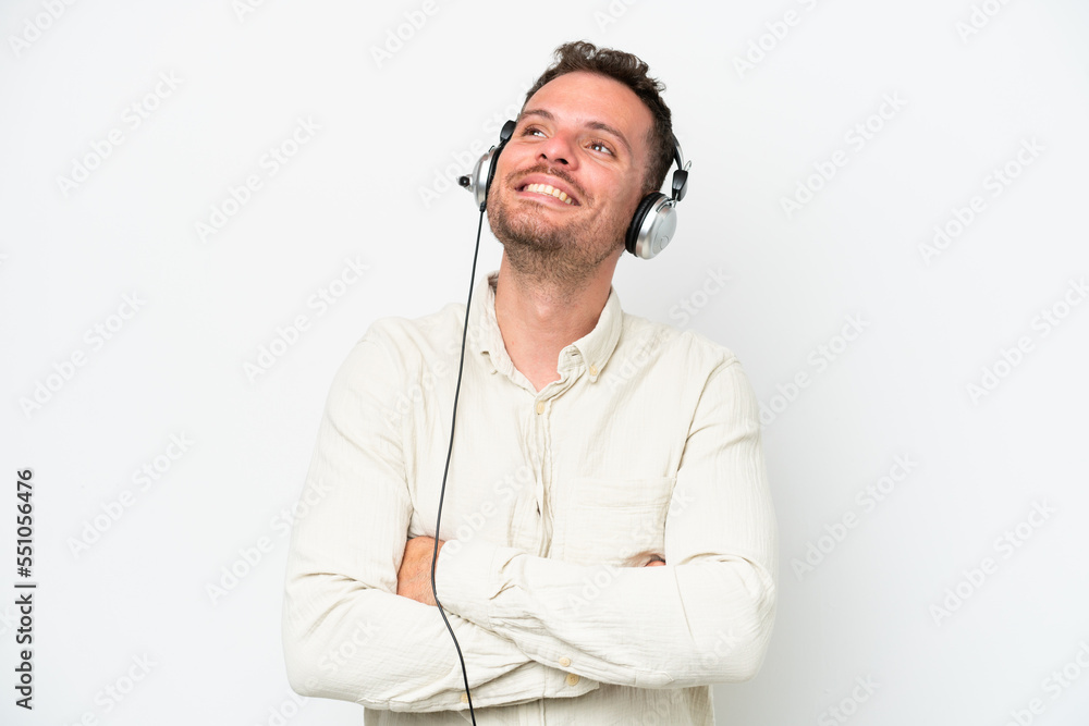 Telemarketer caucasian man working with a headset isolated on white background looking up while smiling Telemarketer caucasian man working with a headset isolated on white background looking up while smiling