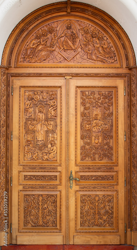 A carved wooden door at the Orthodox church in Reghin city - Romania
It is handmade with floral and religious motifs
