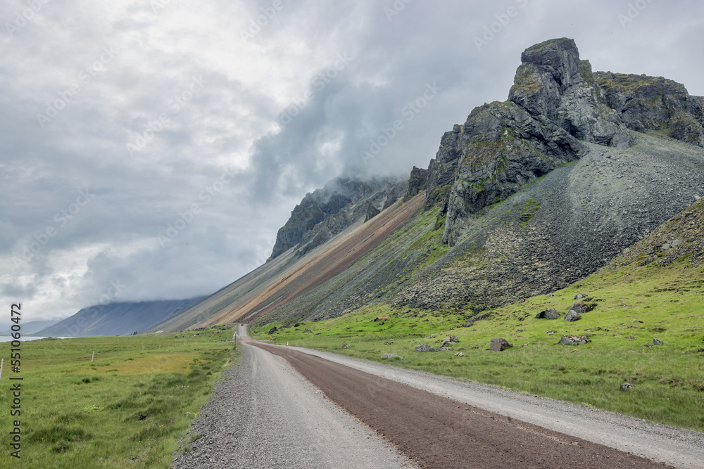 Dirt road at Iceland near Stokksnes cape with mountain peaks