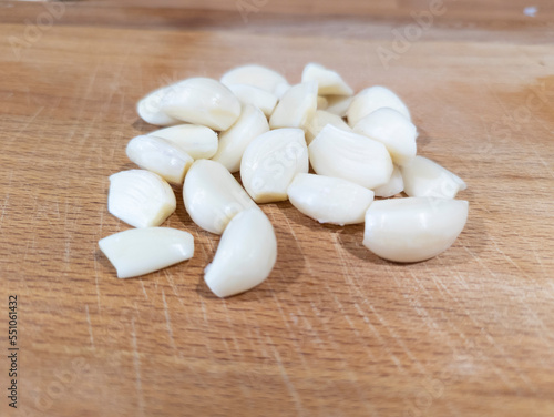 fresh peeled garlic on a cutting board in a kitchen