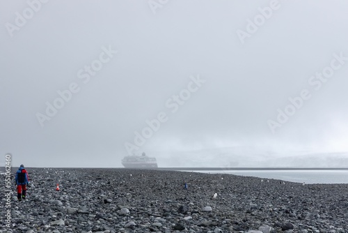 Hiker at the rocky and foggy shore in Antarctica