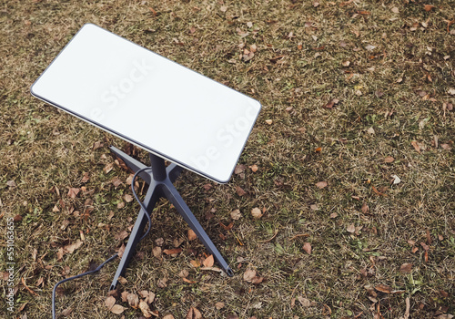 An antenna for receiving the Internet signal from space Starlink on the ground in the park