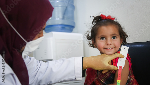 Doctor examines child malnutrition. Measuring malnutrition using strap MUAC mid-upper-arm-circumference.	
 photo