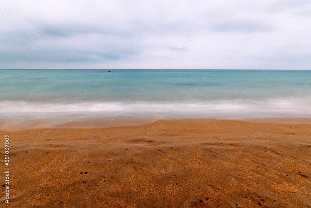 Abstract seascape on the beach. Long exposure photography with the motion of the waves. Abstract background with space for copy. Nature concept