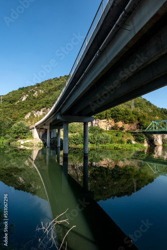Two bridges over the river - one railway and one traffic bridge. Reflections in the water. © Ivan