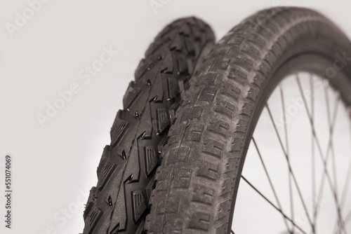 Old damaged bicycle tire with worn out spikes next to a new tire, road safety concept for cycling