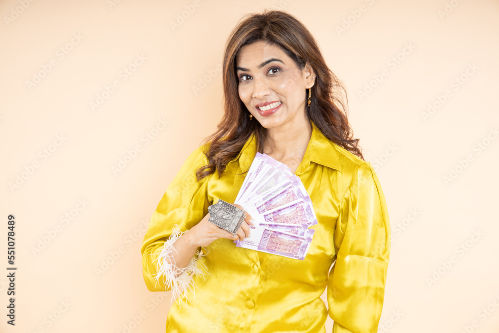 Happy young woman wearing casual yellow cloth showing indian rupee note isolated on white background, Beautiful female model holding lots of cash. Happy young woman wearing casual yellow cloth showing indian rupee note isolated on white background, Beautiful female model holding lots of cash.