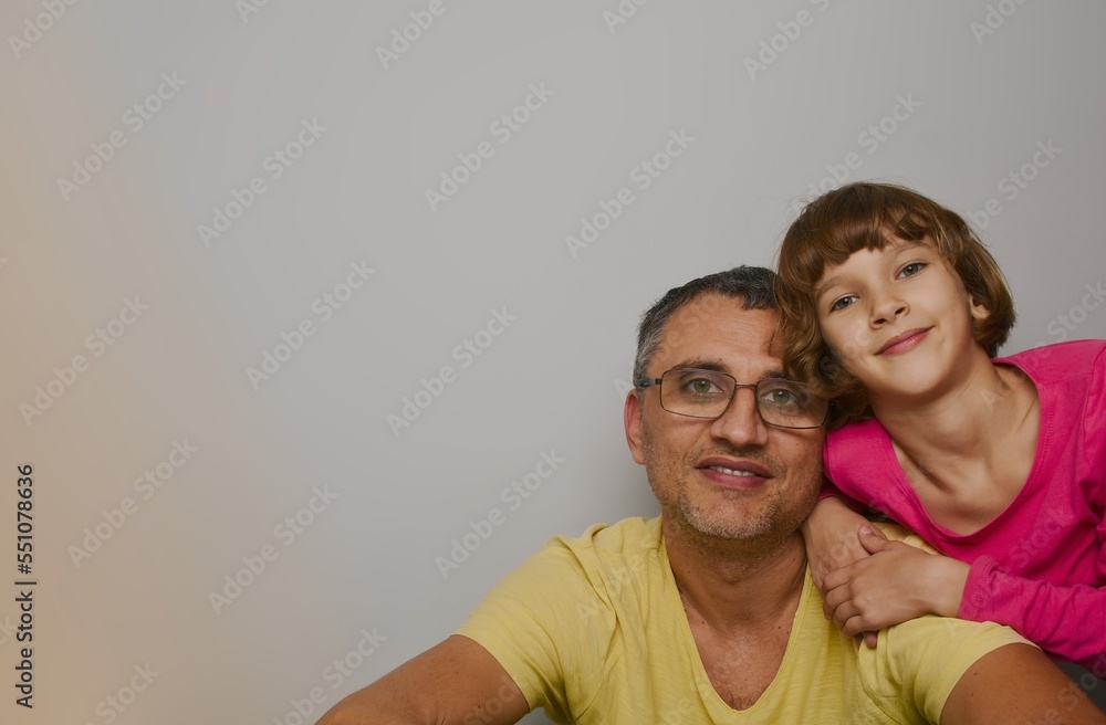 Fototapeta premium Dad and daughter in the right corner of the photo, both are happy looking at the camera, the left corner is empty