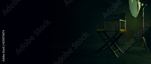 Director chair with cinema lightbox sign Director text on it and clapperboard megaphone and black background studio. Director seat on video production or filming set used in film industry. Real no 3D photo