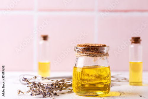 Natural skin care products. Bottles with organic lavender oil against pink tiled wall.   Beauty blogging, salon treatment concept. Selective focus. Place for text.