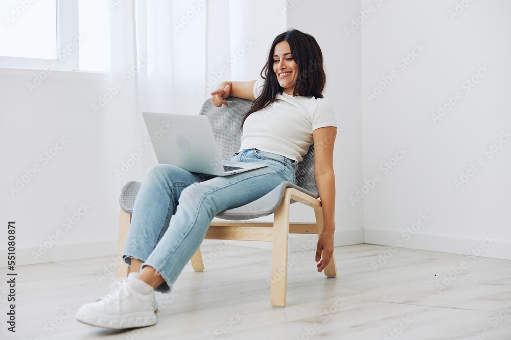 Woman relaxing at home sitting in a chair with a laptop, lifestyle home mood. Mockup, free copy space Woman relaxing at home sitting in a chair with a laptop, lifestyle home mood. Mockup, free copy space