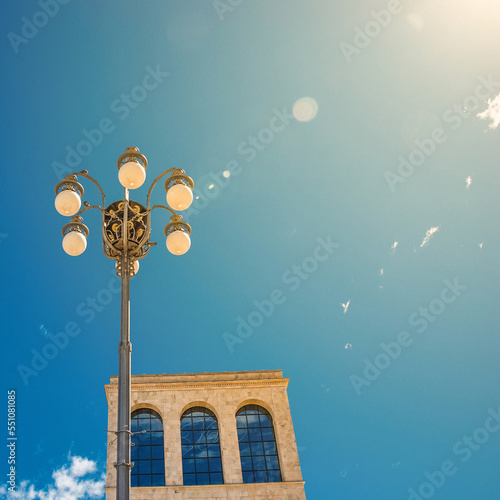 Happy sunny day near an old Italian building with windows, street light and direct sunshine with lens flare and copy space photo