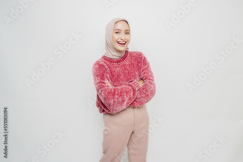 Sticker Portrait of a confident smiling Asian Muslim woman wearing pink sweater and hija