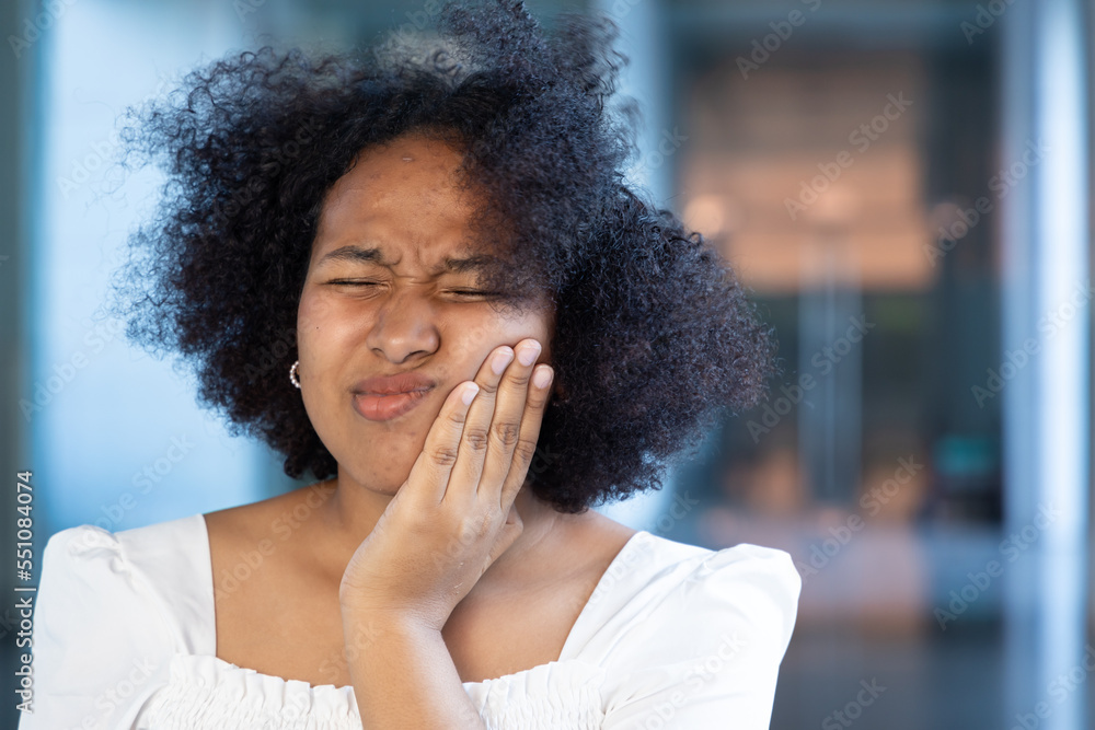 African woman suffering from toothache, tooth decay, tooth sensitivity ...