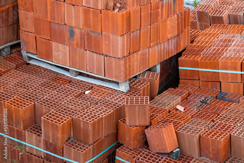 Orange clay block at construction site, Orange hollow brick, in pallet stacked, stretch-wrapped