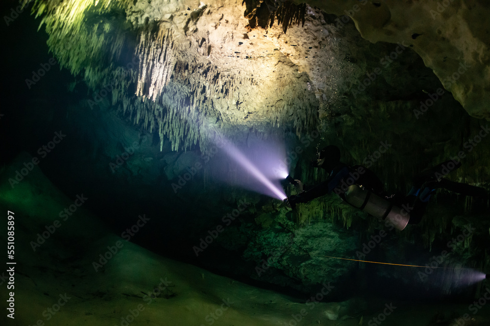 Obraz premium cave diver instructor leading a group of divers in a mexican cenote underwater