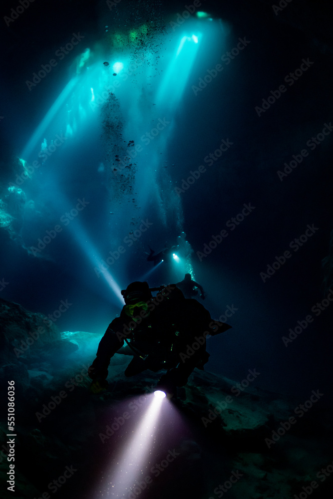 cave diver instructor leading a group of divers in a mexican cenote underwater cave diver instructor leading a group of divers in a mexican cenote underwater