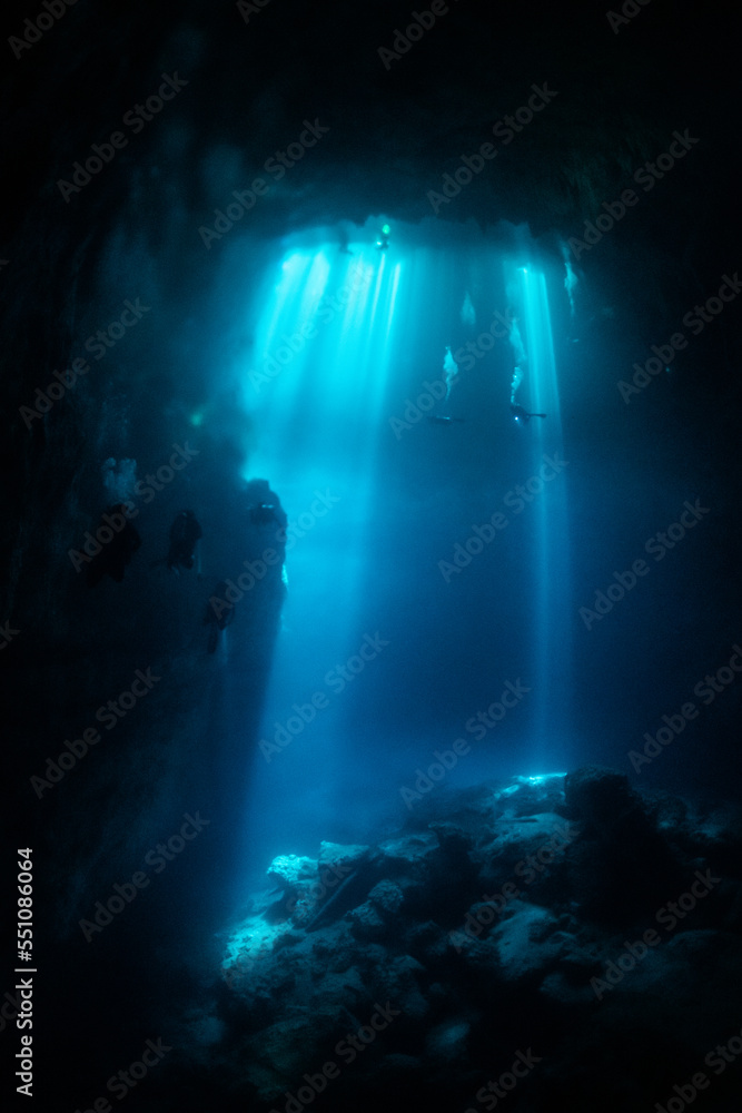 cave diver instructor leading a group of divers in a mexican cenote underwater cave diver instructor leading a group of divers in a mexican cenote underwater
