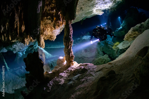 cave diver instructor leading a group of divers in a mexican cenote underwater