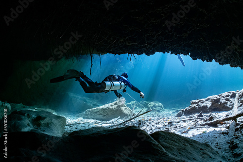 Fotografie cave diver instructor leading a group of divers in a mexican cenote underwater
