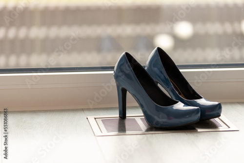 Blue high heel pumps in front of a window and on a light floor
