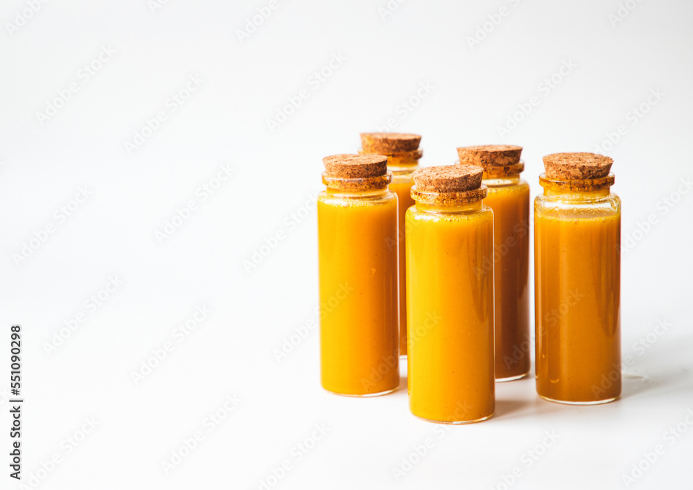 Homemade Immune Boosting Turmeric Ginger Citrus Shots. Anti-Inflammatory Healthy Drink. Still Life on white background, top view. Natural Immunity System Booster Homemade Immune Boosting Turmeric Ginger Citrus Shots. Anti-Inflammatory Healthy Drink. Still Life on white background, top view. Natural Immunity System Booster