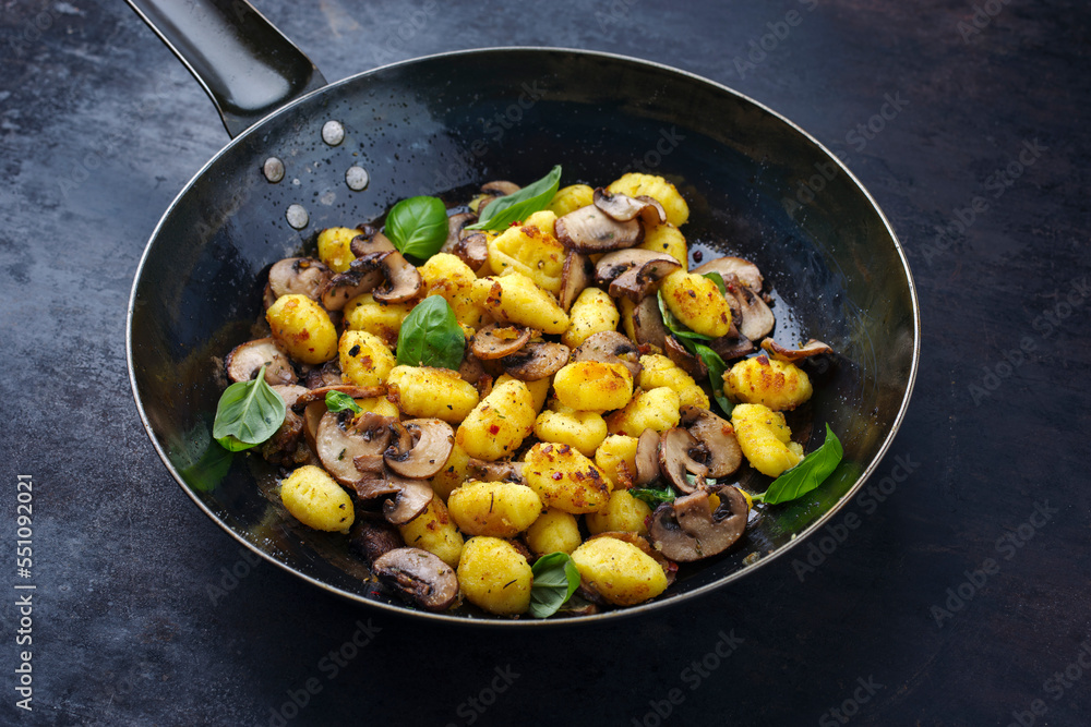 Traditional Italian gnocchi di patate with mushrooms as close-up in a frying pan with copy space Traditional Italian gnocchi di patate with mushrooms as close-up in a frying pan with copy space