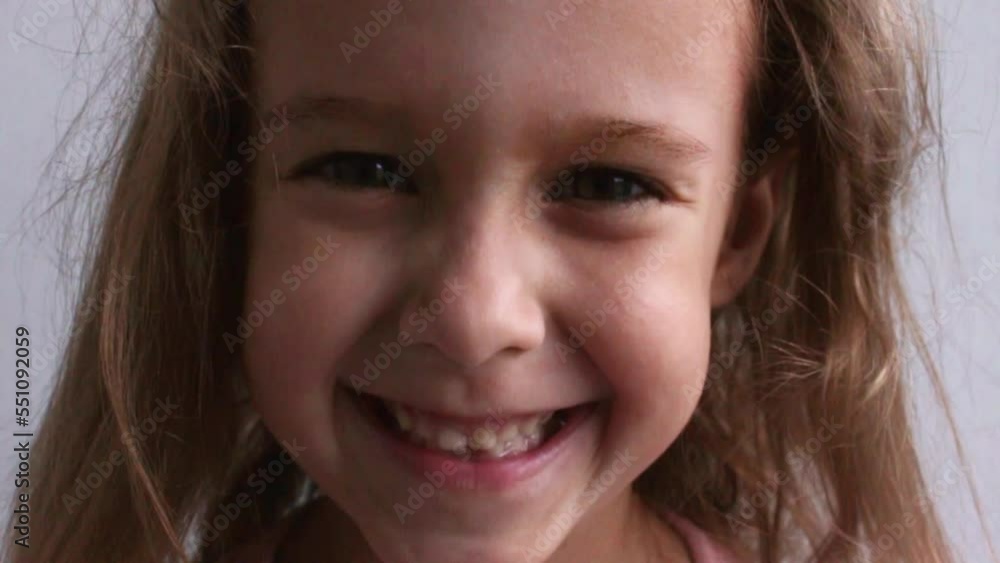 Childish laughing baby close-up portrait. A beautiful little girl smiles at the camera. Video Childish laughing baby close-up portrait. A beautiful little girl smiles at the camera. Video