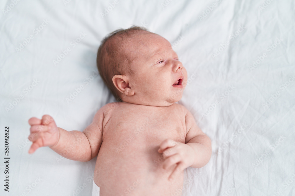 Adorable caucasian baby lying on bed crying at bedroom Adorable caucasian baby lying on bed crying at bedroom