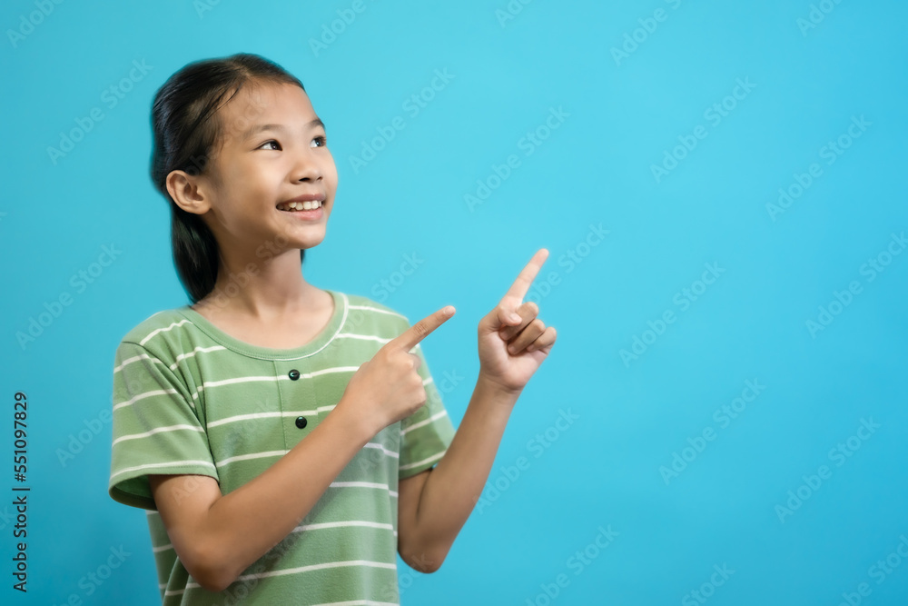 Smiling Asian kid of little girl close up photo of cute and cheerful people, looking and smile on blue pastel background Smiling Asian kid of little girl close up photo of cute and cheerful people, looking and smile on blue pastel background