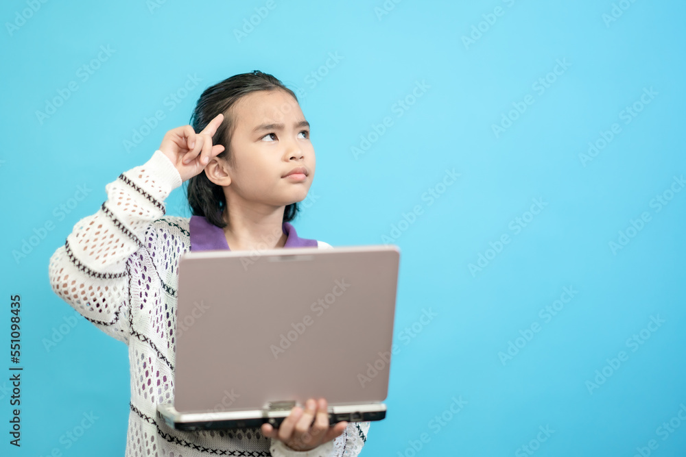 Children close up photo of cute and cheerful people, holding labtop looking and smile on blue pastel background Children close up photo of cute and cheerful people, holding labtop looking and smile on blue pastel background