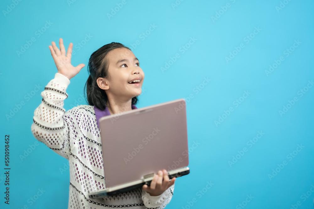 Children close up photo of cute and cheerful people, holding labtop looking and smile on blue pastel background Children close up photo of cute and cheerful people, holding labtop looking and smile on blue pastel background