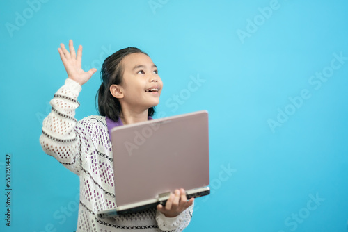 Kid smart and curious, children close up photo of cute and cheerful people, holding labtop looking and smile on blue pastel background © Torychemistry