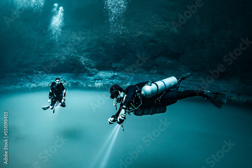 Fotografie cave diver instructor leading a group of divers in a mexican cenote underwater