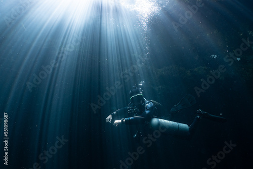 Fototapeta Naklejka Na Ścianę i Meble -  cave diver instructor leading a group of divers in a mexican cenote underwater