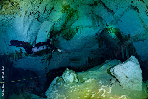 cave diver instructor leading a group of divers in a mexican cenote underwater