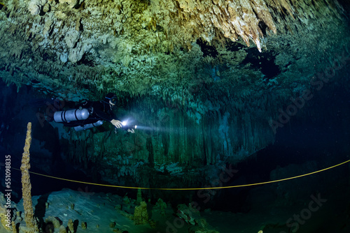 cave diver instructor leading a group of divers in a mexican cenote underwater