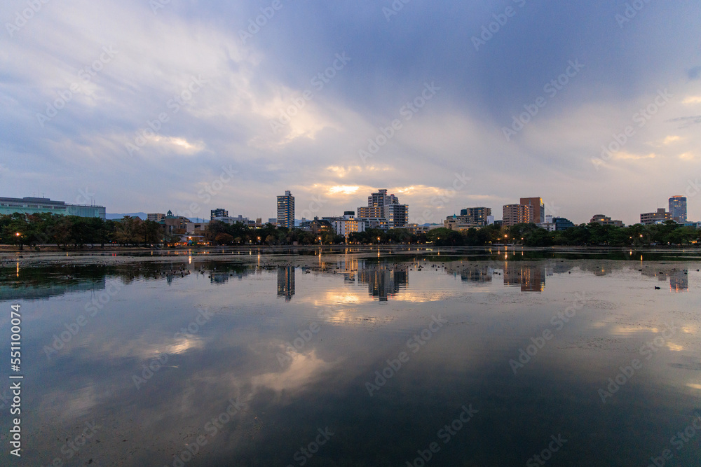 Waterfront apartments with lights and dramatic sky after sunset