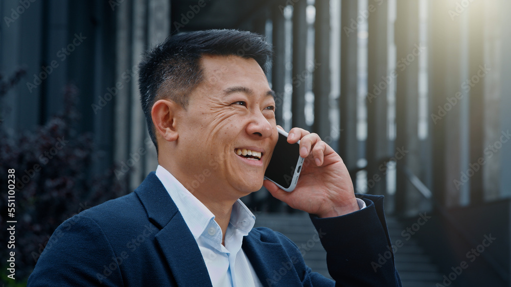 Emotional smiling happy Asian Korean 40s adult mature leader worker investor entrepreneur businessman man talking mobile phone outdoors in city distant cellphone talk answer call smartphone calling Emotional smiling happy Asian Korean 40s adult mature leader worker investor entrepreneur businessman man talking mobile phone outdoors in city distant cellphone talk answer call smartphone calling
