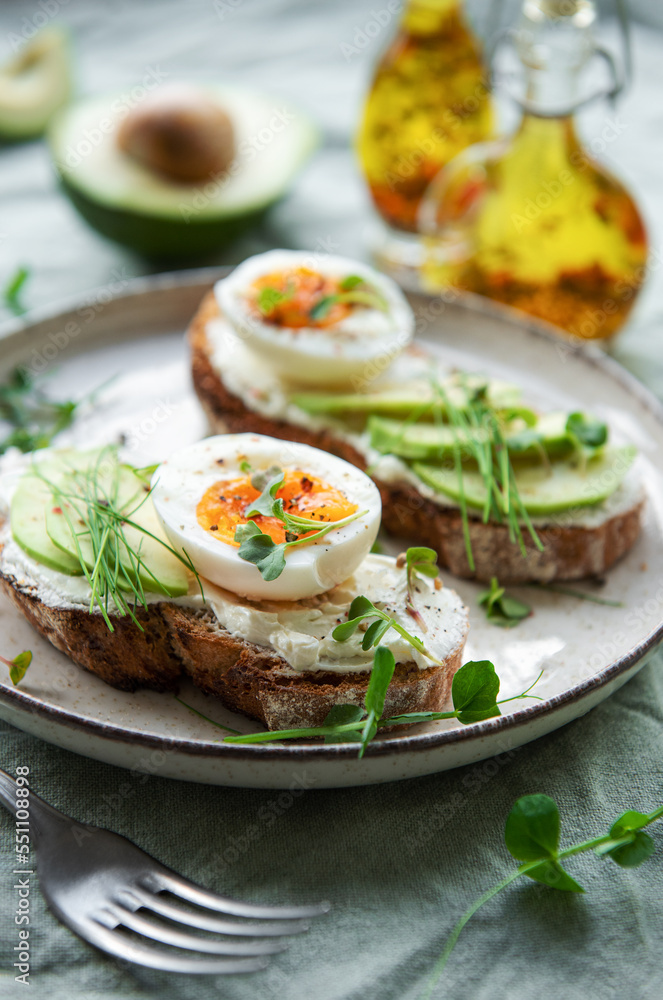 Bread toast, boiled eggs, avocado slice, microgreens on a plate Bread toast, boiled eggs, avocado slice, microgreens on a plate
