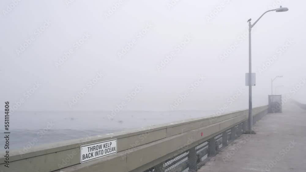 Wooden Ocean Beach pier in fog, misty California coast, USA. Foggy moody cloudy weather on San Diego shore. Calm tranquil silent atmosphere. Waterfront boardwalk in gloomy depressive dramatic haze. Wooden Ocean Beach pier in fog, misty California coast, USA. Foggy moody cloudy weather on San Diego shore. Calm tranquil silent atmosphere. Waterfront boardwalk in gloomy depressive dramatic haze.