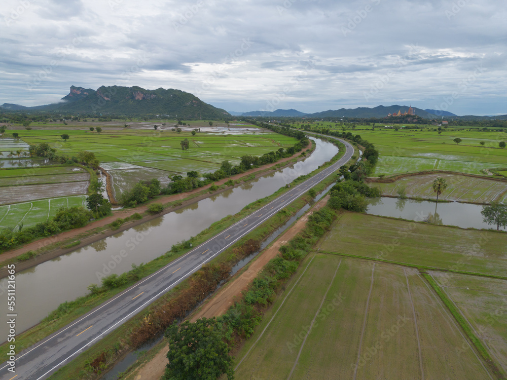 Aerial top view of road or street on mountain hill with green natural forest trees in rural area of Thailand. Transportation.