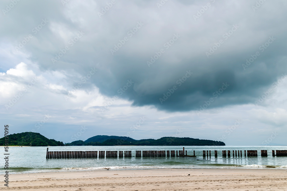 Rain clouds over Chenang beach near the Andaman Sea on Langkawi island, Malaysia. Natural landscape of a tropical beach. Bad weather at the resort.