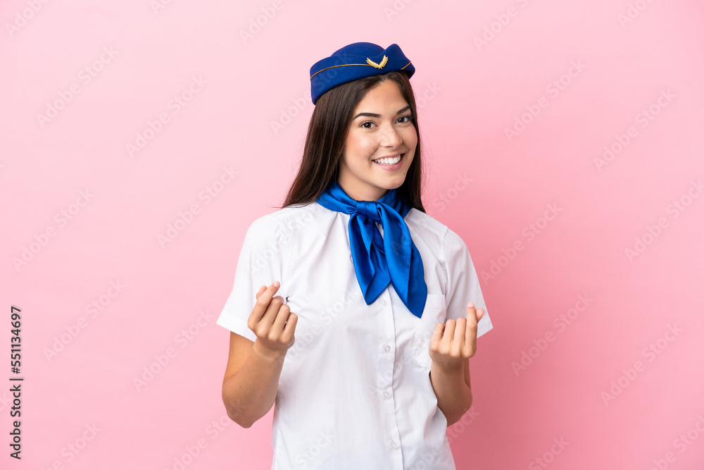 Airplane stewardess Brazilian woman isolated on pink background making money gesture Airplane stewardess Brazilian woman isolated on pink background making money gesture