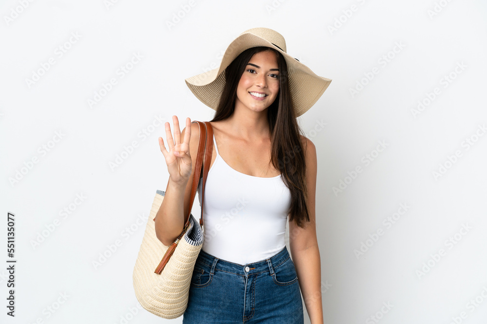 Young Brazilian woman with Pamela holding a beach bag isolated on white background happy and counting four with fingers Young Brazilian woman with Pamela holding a beach bag isolated on white background happy and counting four with fingers