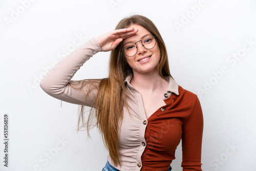 Young caucasian woman isolated on white background saluting with hand with happy expression